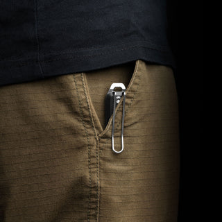 James The Ellis Slim Knife clipped to the side pocket of brown textured pants in a close-up shot