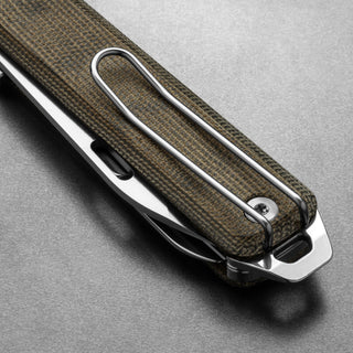 James The Ellis Scissors Knife with textured Micarta handle and sleek metal clip on gray surface