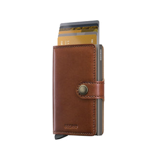 Secrid Miniwallet Texano brown leather wallet with buttoned strap and cards partially extended