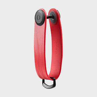 Orbitkey Active Key Organizer in red TPU with black stainless steel fasteners angled on grey background