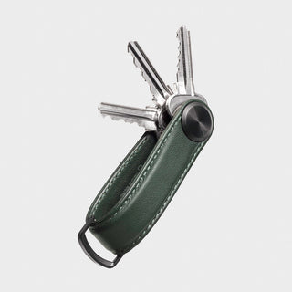 Orbitkey Key Organizer Pro Leather in dark green holding three silver keys with metal detailing and stitched edges