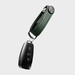 Orbitkey Key Organizer Pro Leather in dark green holding a car key fob with silver hardware detail