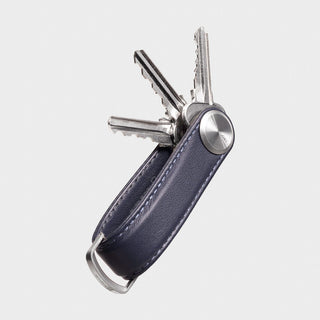 Orbitkey Key Organizer Pro Leather in dark blue holding three silver keys with metal button closure