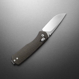 James The Carter Knife with textured dark Micarta handle and sharp VG-10 steel blade angled on gray background