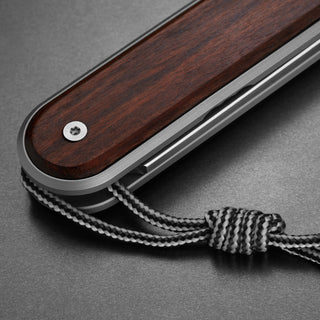 James The Duval Knife showing rosewood handle texture with stainless steel frame and lanyard detail