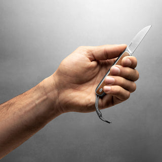 James The Pike Knife held showing stainless steel blade and wooden handle detail in natural light