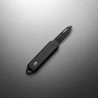 James The Elko Knife with black handle and compact Sandvik steel blade on gray background