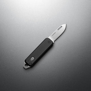 James The Elko Knife with black G10 handle and polished Sandvik 12C27 steel blade open on gray background