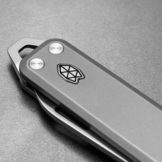 James The Elko Knife closed view with matte gray titanium handle and geometric logo from The James Brand