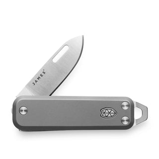 James The Elko Knife partially open showing satin blade and titanium handle with emblem by The James Brand