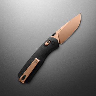 James The Carter Knife with black textured handle and copper-colored VG-10 blade resting diagonally on gray surface