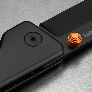 Close-up of James The Chapter 2 Knife showing black frame lock and orange anodized thumb stud by The James Brand