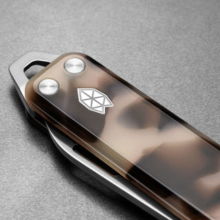 James The Elko Knife showing eco-acetate handle with metallic emblem and stainless steel hardware close-up