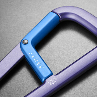 James The Hardin Carabiner showing dual compartment anodized aluminum body with blue latch close-up