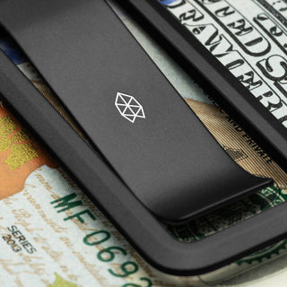 James The Martindale Money Clip in matte black titanium with subtle geometric logo on folded bills