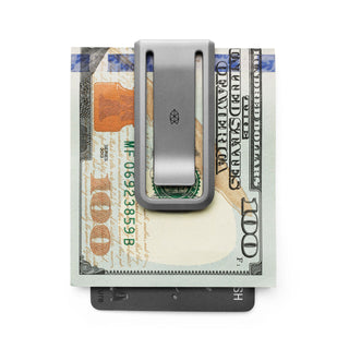 James The Martindale Money Clip in titanium securing folded cash and a black card beneath