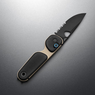 James The Redstone Knife with black serrated blade and beige textured polypropylene handle angled on gray surface