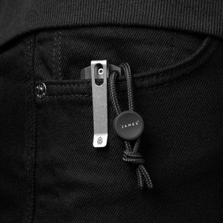 James The Ulu Lanyard & Bead clipped to black denim pocket with titanium and aluminum materials visible
