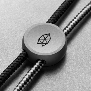 James The Ulu Lanyard & Bead showing anodized aluminum bead with geometric engraving on black and white paracord strands