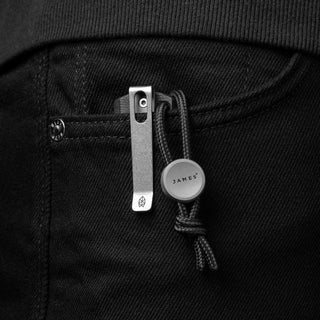 James The Ulu Lanyard & Bead clipped on black fabric pocket with titanium clip and nylon paracord bead