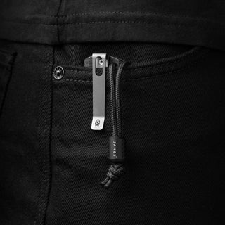 James The Alder Lanyard & Bead in titanium and nylon paracord clipped on black denim pocket