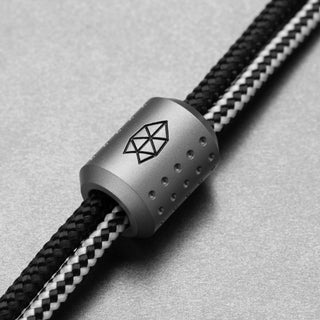 James The Alder Lanyard & Bead titanium bead with engraved graphic threaded on black and white paracord rope