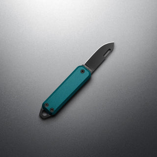 James The Elko Knife with teal Micarta handle and stainless steel blade against gray background