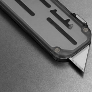 James The Palmer Recycled PC Knife with translucent handle and sharp high carbon steel blade angled on gray surface
