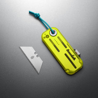 James The Palmer Recycled PC Knife with translucent yellow recycled handle and blue cord lanyard next to utility blade