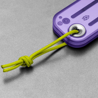 James The Palmer Recycled PC Knife purple handle with lime green cord detail on gray surface