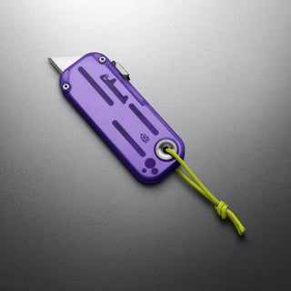 James The Palmer Recycled PC Knife in purple with anodized aluminum and neon yellow lanyard on gray surface