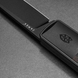 James The Wayland Knife close-up showing black blade and geometric emblem on ebony handle