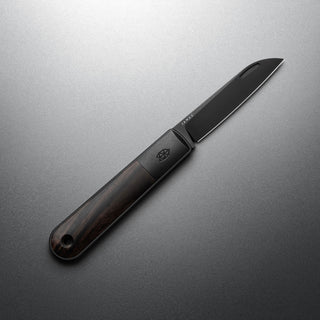 James The Wayland Knife with dark rosewood handle and sleek black steel blade on gray background