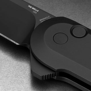 James The Wells Knife close-up showing matte black finish and button lock on aerospace aluminum handle