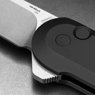 Close-up of James The Wells Knife showing button lock and aerospace aluminum handle details