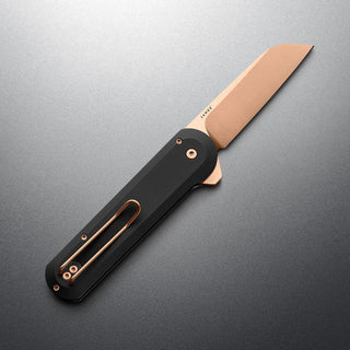 James The Wells Knife with black handle and rose gold blade by The James Brand on gray background