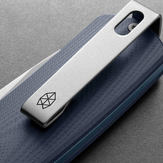 James The Carter Knife with textured blue G10 handle and engraved stainless steel pocket clip close-up