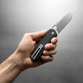 Hand holding James The Folsom Pro Knife by The James Brand with textured black G10 handle and stonewash blade