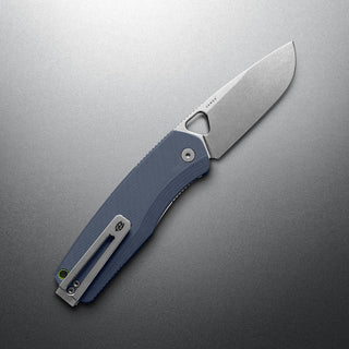 James The Folsom Pro Knife with stonewash LC200N blade and textured blue G10 handle angled on gray surface