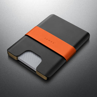 James The Lowe Wallet with black aluminum body and orange silicone band showing card access slot