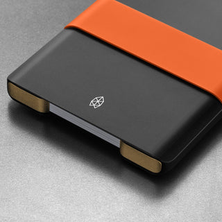 James The Lowe Wallet in black aluminum with orange silicone band and compact card capacity design