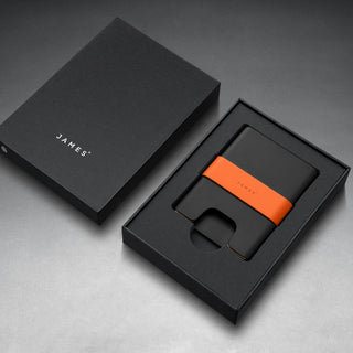 James The Lowe Wallet with black aluminum body and bright orange silicone band in sleek packaging