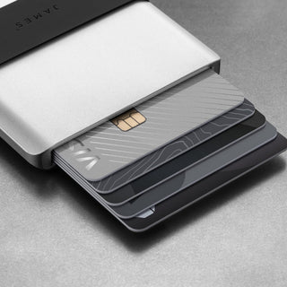James The Lowe Wallet by The James Brand in silver aluminum with cards partially ejected on gray surface