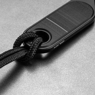 James The Abbey Knife handle made of rosewood with black cord lanyard detail on textured surface