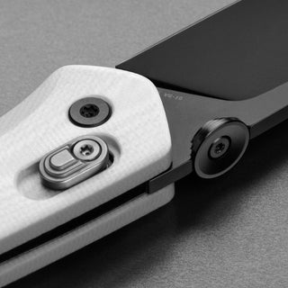 Close-up of James The Carter Knife showing white Micarta handle and black VG-10 steel blade locking mechanism