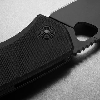 James The Folsom Knife close-up on textured black G10 handle with serrated VG-10 blade edge detail