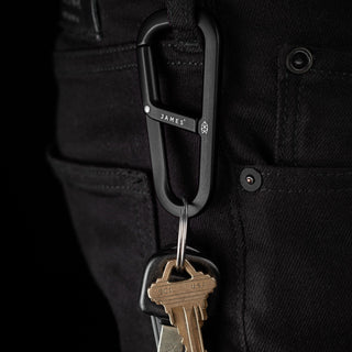 James The Hardin Carabiner in black anodized aluminum attached to black pants holding keys