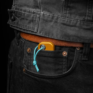 James The Palmer Knife with anodized gold aluminum handle and blue lanyard in black denim pocket