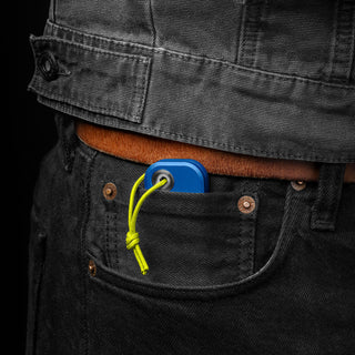 James The Palmer Knife in blue anodized aluminum shown clipped to black jeans pocket with yellow cord