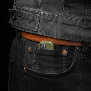 James The Palmer Knife in olive anodized aluminum tucked into black jeans pocket with visible lanyard loop